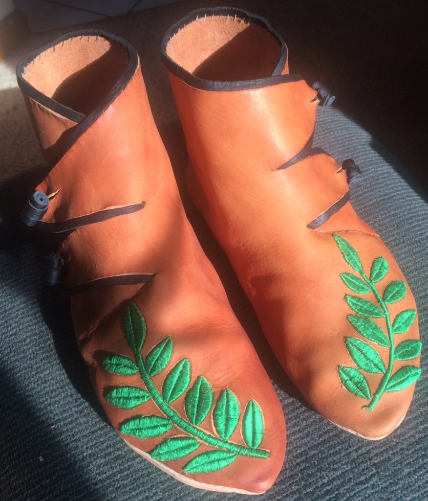 two Viking-style shoes with laurel branches embroidered with green silk