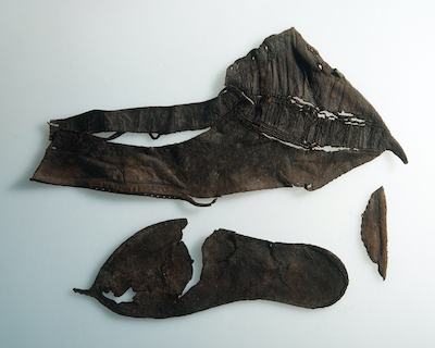 conserved leather shoe pieces with incised lines showing where runic characters and designs were embroidered